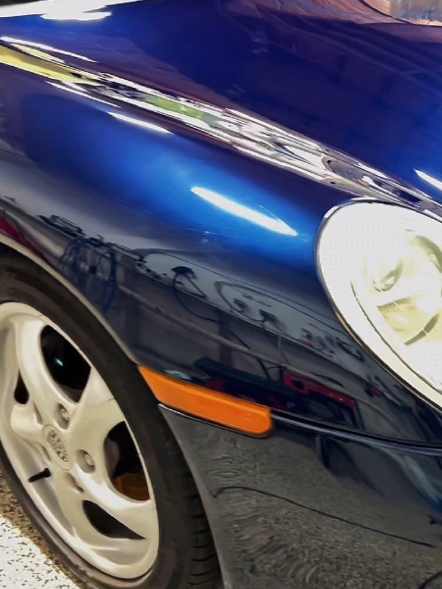 Blue Porsche front-side and wheel detail